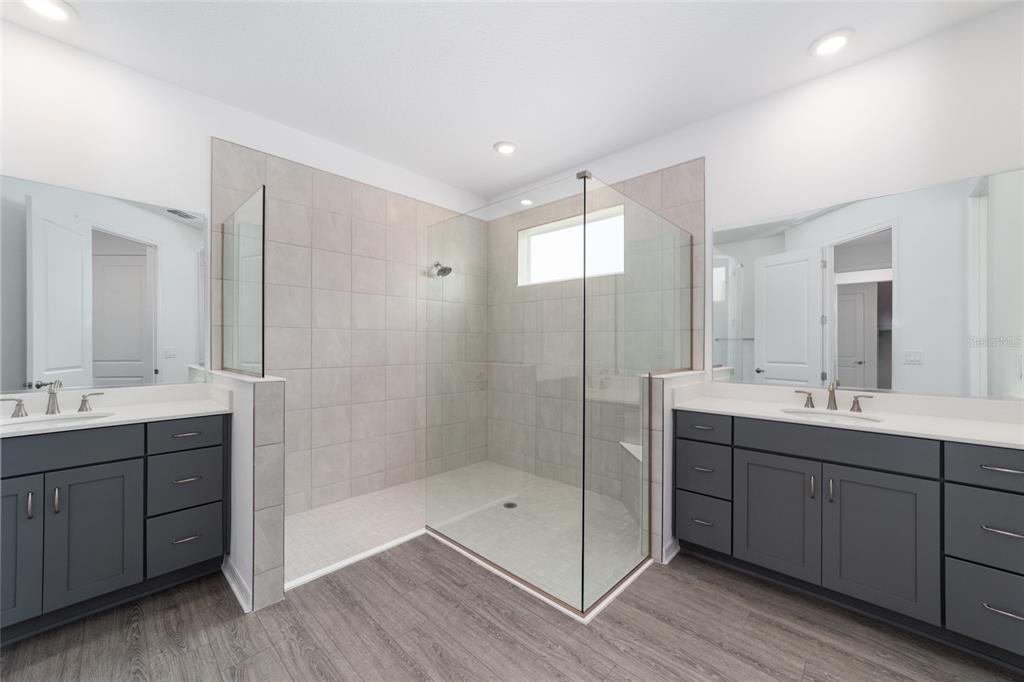 7232 Southwest 63rd Street Ocala, FL 34474 - Photo 28 of 54 a bathroom with a double vanity sink mirror and shower