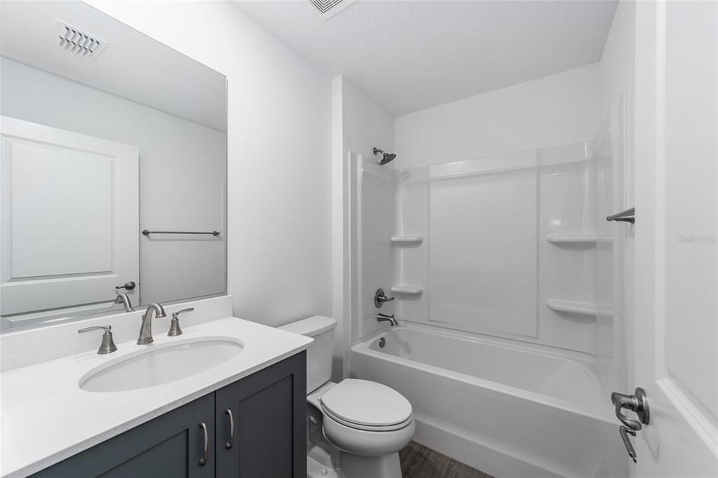 7232 Southwest 63rd Street Ocala, FL 34474 - Photo 44 of 54 a bathroom with a bathtub shower sink mirror vanity and toilet