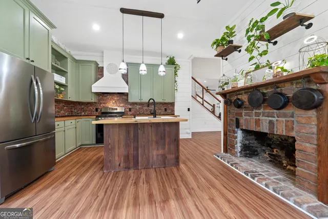 a kitchen with granite countertop a stove a refrigerator and a wooden floor