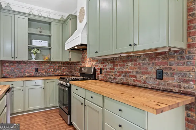 a kitchen with granite countertop a sink a stove and cabinets