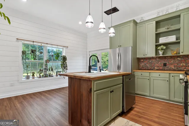 a kitchen with a sink and wooden floor