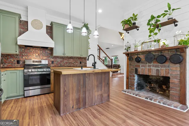 a kitchen with kitchen island a sink stainless steel appliances and cabinets