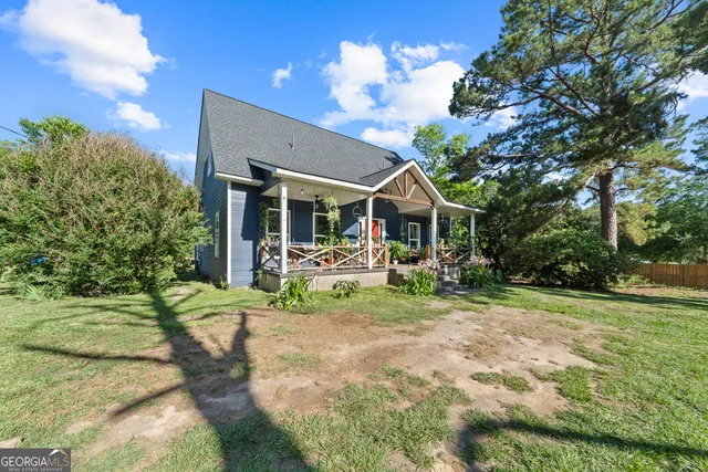 a view of a house with backyard and sitting area
