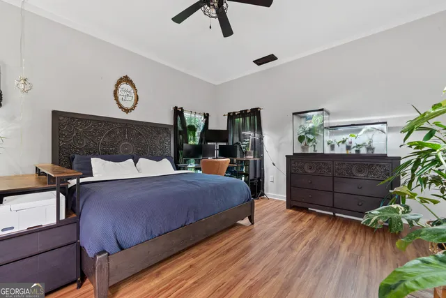 a bedroom with a bed and wooden floor