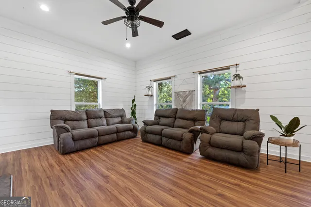 a living room with furniture and a wooden floor