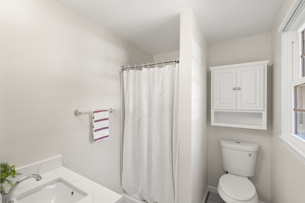 154 Danforth Street Framingham, MA 01701 - Photo 15 of 30 a white toilet sitting next to a shower curtain