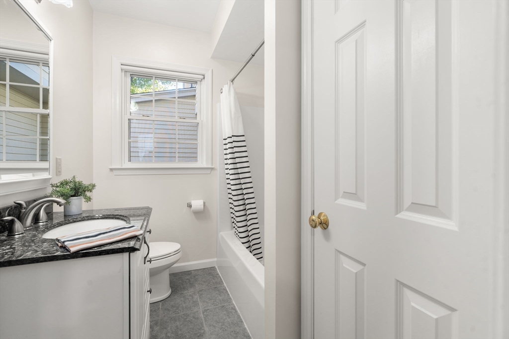 154 Danforth Street Framingham, MA 01701 - Photo 24 of 30 a bathroom with a granite countertop sink a toilet and a window