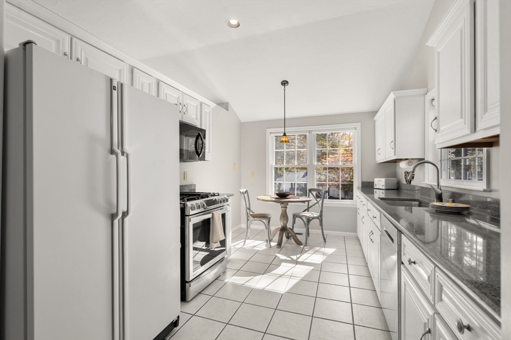 154 Danforth Street Framingham, MA 01701 - Photo 7 of 30 a kitchen with granite countertop a sink appliances cabinets and furniture
