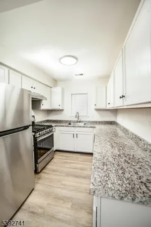 a kitchen with stainless steel appliances white cabinets and a refrigerator