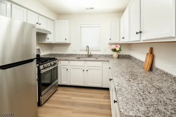 a kitchen with granite countertop white cabinets and white appliances