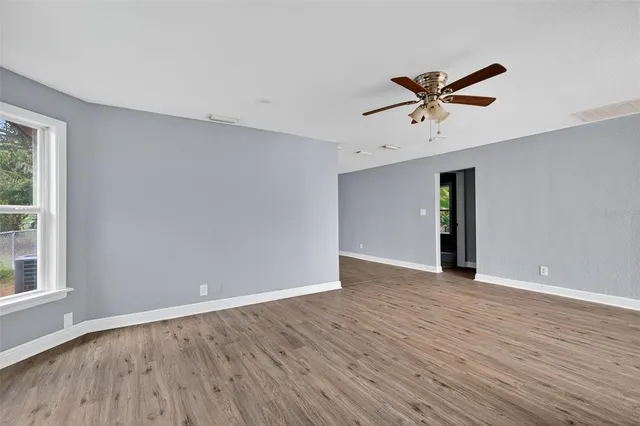a view of an empty room with wooden floor