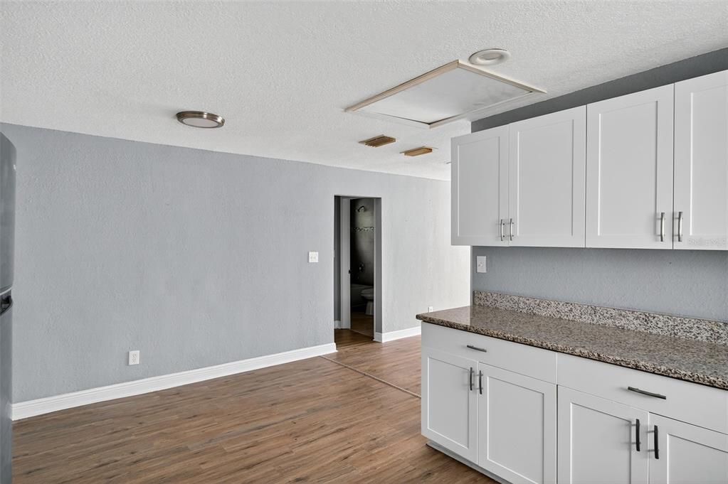 5801 Virginia Avenue New Port Richey, FL 34652 - Photo 24 of 81 a kitchen with granite countertop wooden cabinets and white appliances