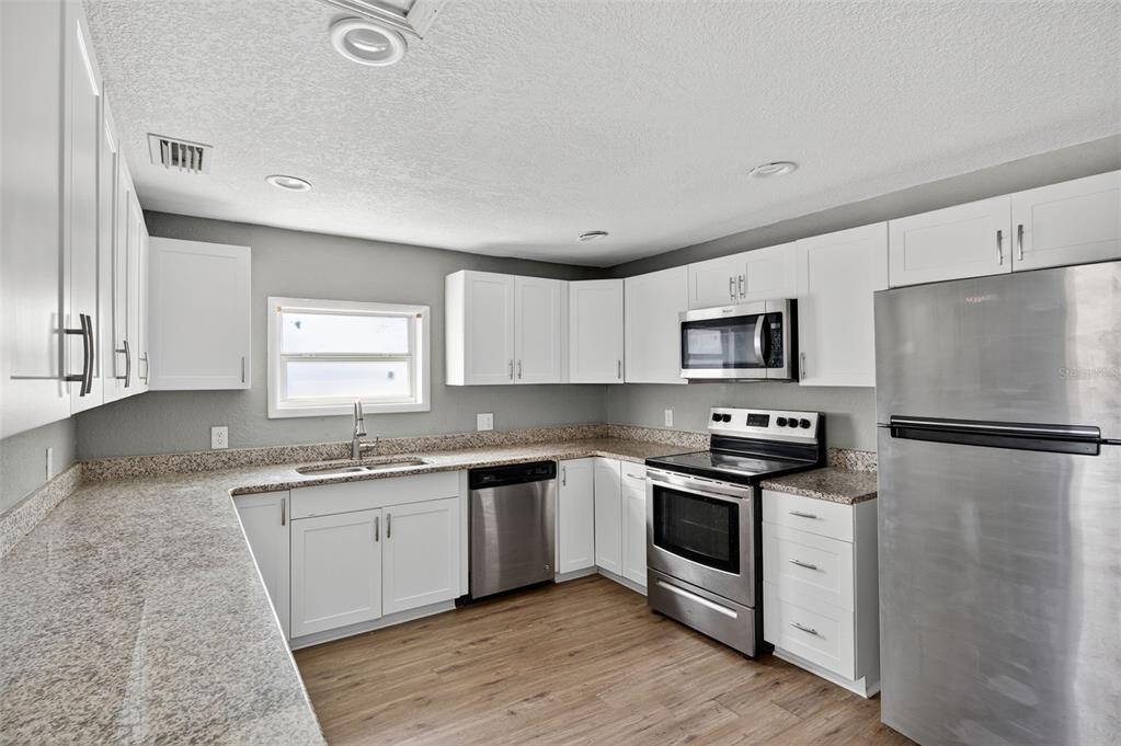 5801 Virginia Avenue New Port Richey, FL 34652 - Photo 26 of 81 a kitchen with stainless steel appliances a sink stove and refrigerator