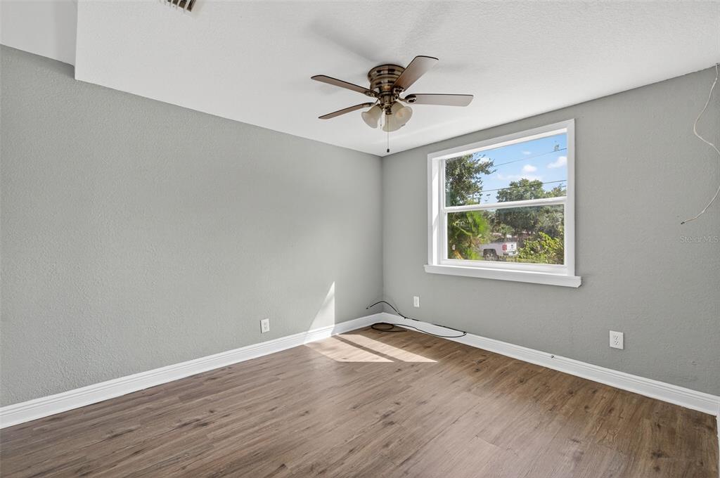 5801 Virginia Avenue New Port Richey, FL 34652 - Photo 29 of 81 a view of an empty room with wooden floor and a window