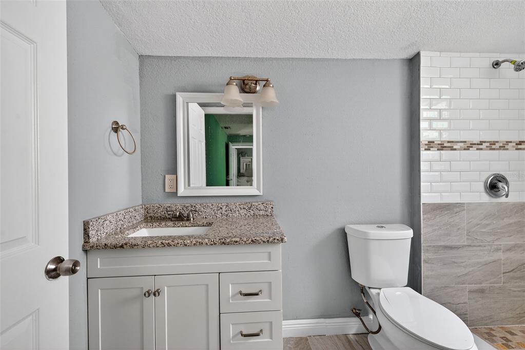 5801 Virginia Avenue New Port Richey, FL 34652 - Photo 37 of 81 a bathroom with a granite countertop toilet sink and mirror