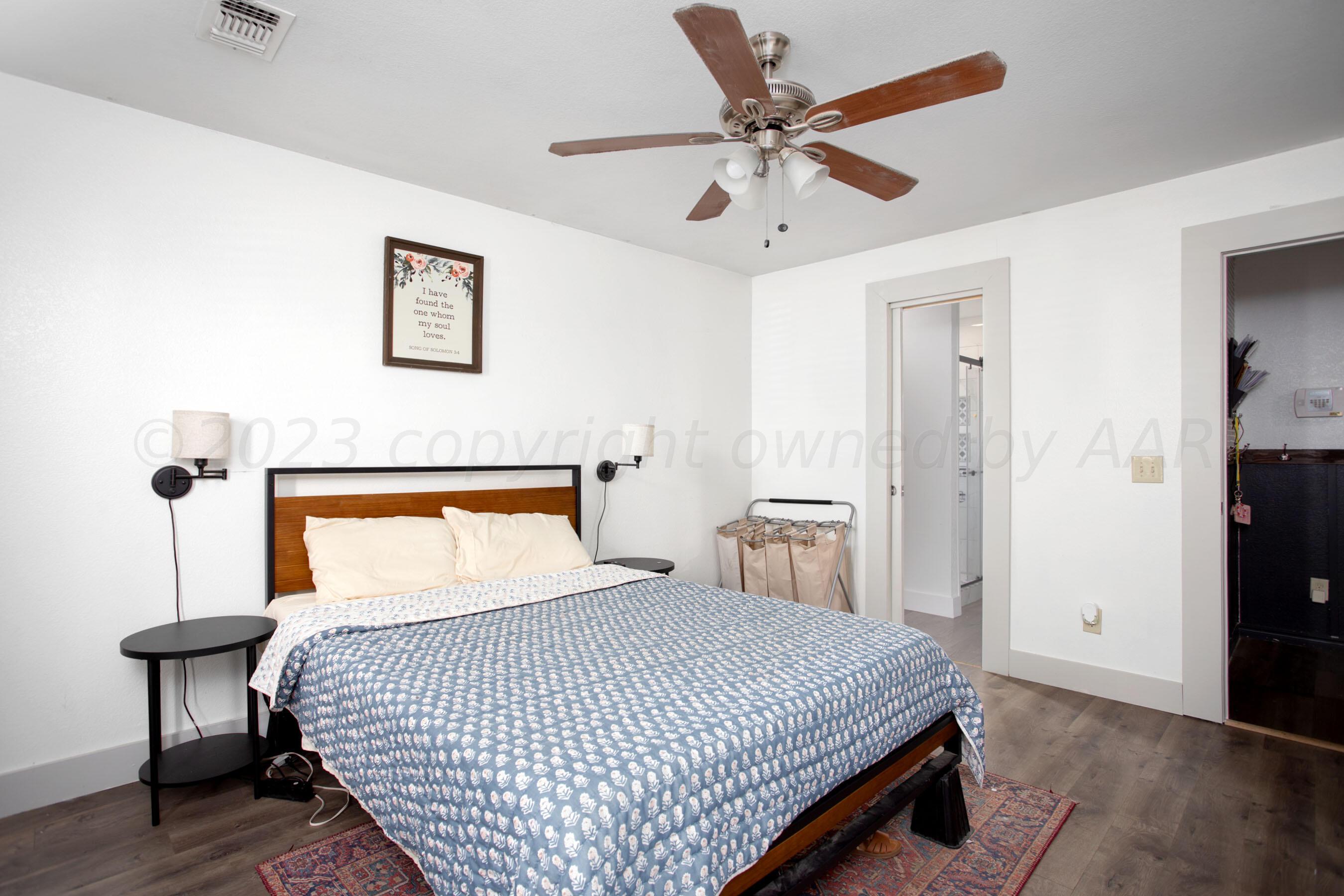 4511 South Roberts Street Amarillo, TX 79118 - Photo 11 of 26 a bedroom with a bed and a chandelier