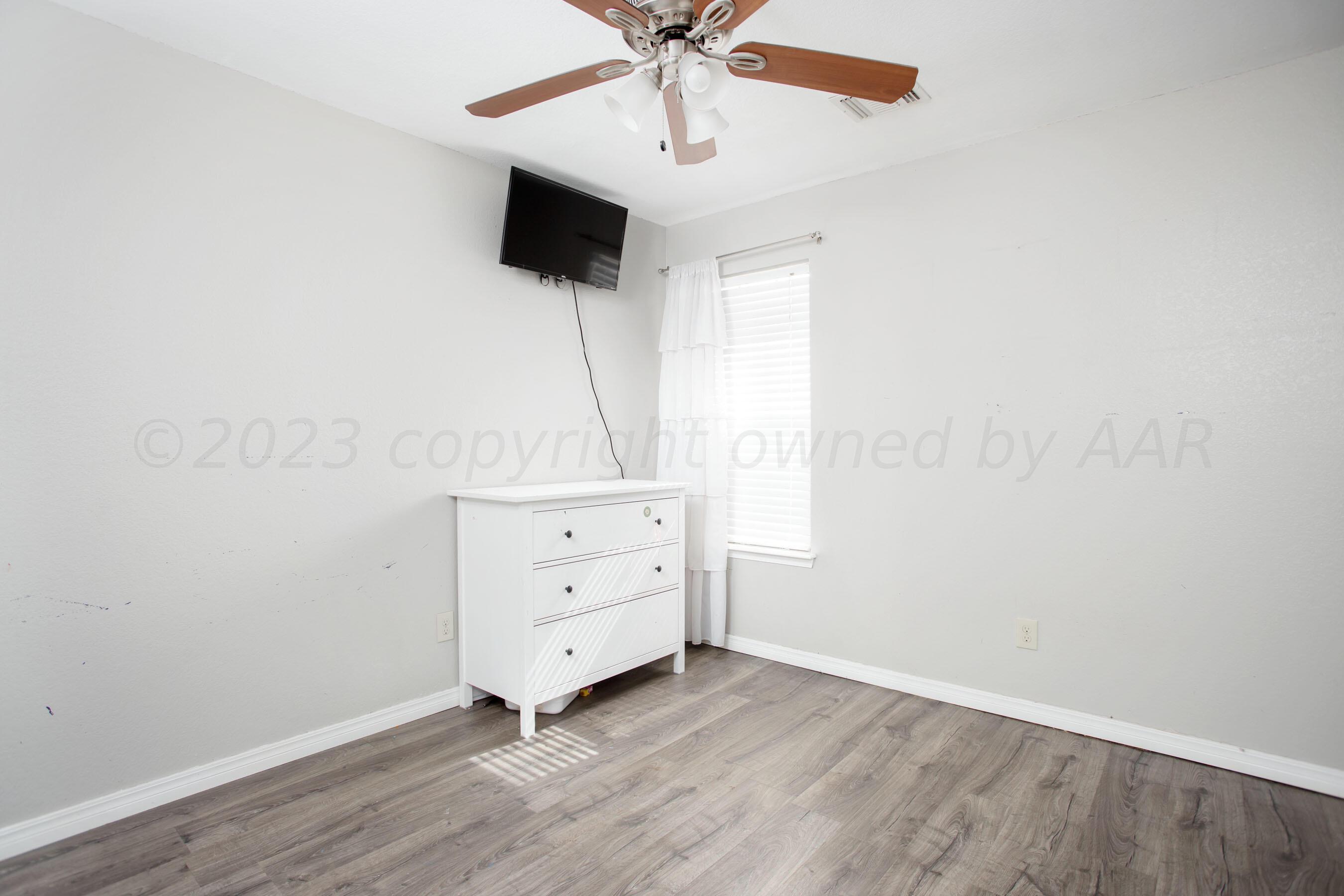 4511 South Roberts Street Amarillo, TX 79118 - Photo 16 of 26 an empty room with wooden floor and ceiling fan