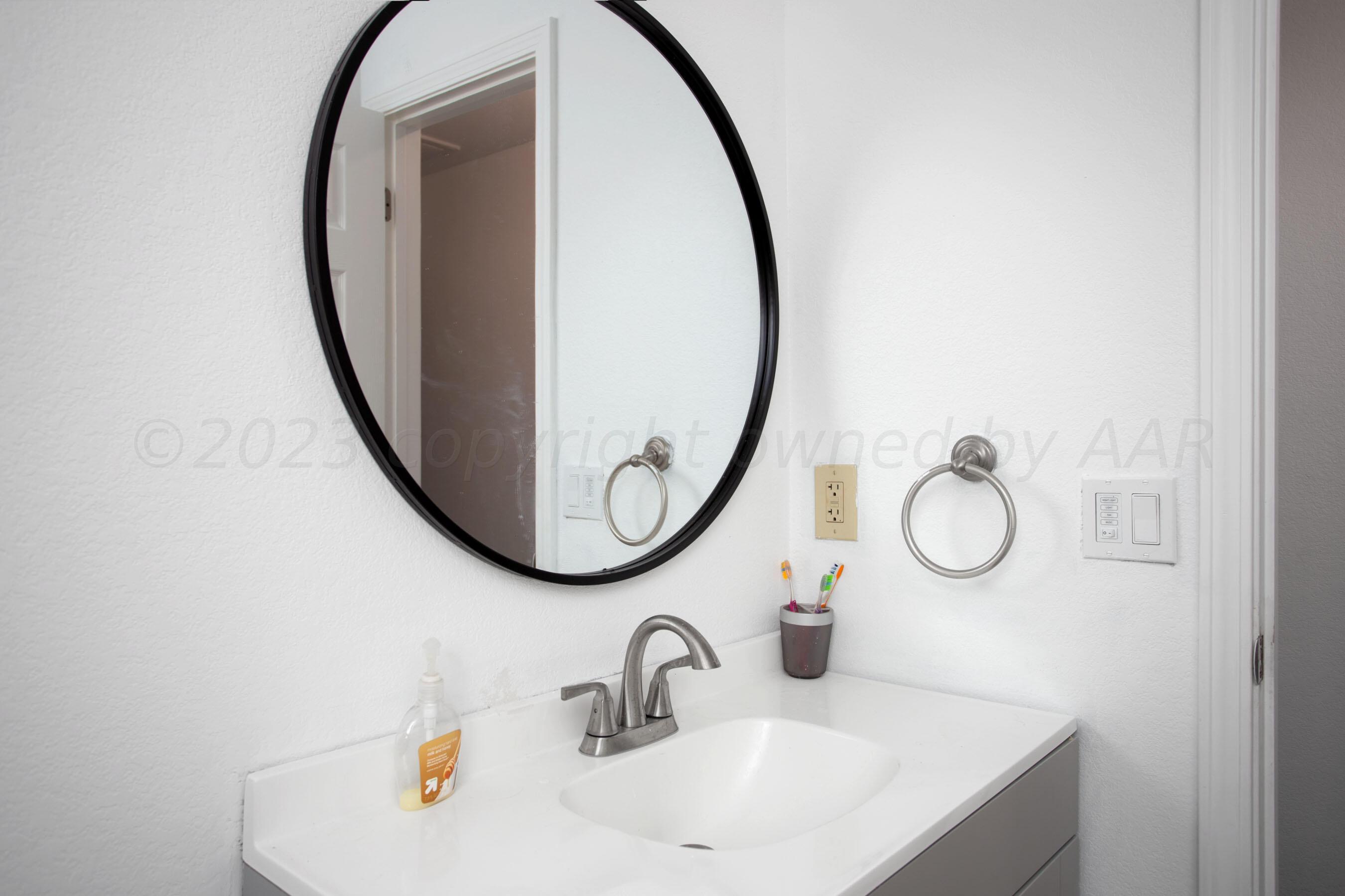 4511 South Roberts Street Amarillo, TX 79118 - Photo 17 of 26 a bathroom with a sink and a mirror