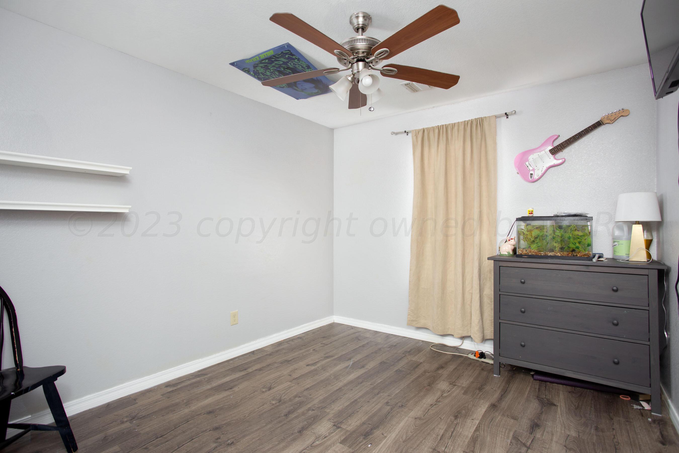 4511 South Roberts Street Amarillo, TX 79118 - Photo 19 of 26 a view of an empty room with wooden floor and a ceiling fan