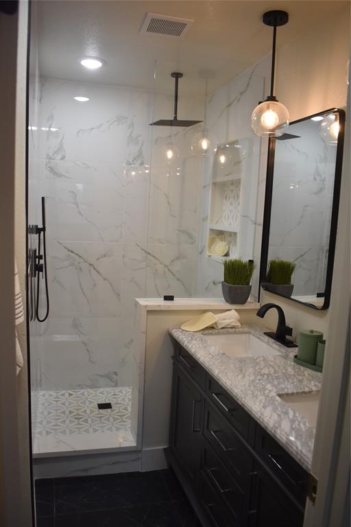 2908 Washington Street Commerce, TX 75428 - Photo 38 of 40 Bathroom featuring a glass-enclosed shower with geometric-patterned floor tiling and a matte black rain shower head