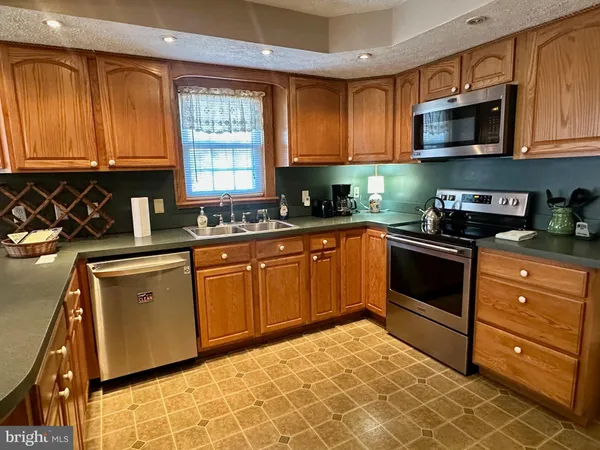 a kitchen with stainless steel appliances granite countertop a sink stove and microwave