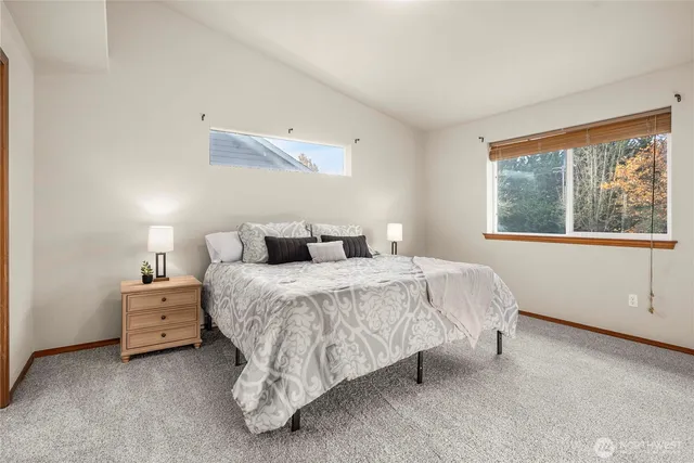 a bedroom with a bed and a large window