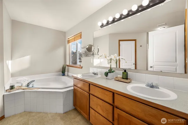 a bathroom with a sink double vanity bathtub and a toilet