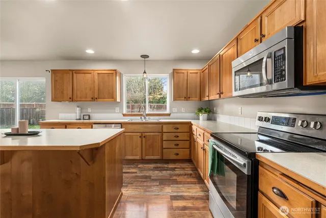 a kitchen with stainless steel appliances granite countertop a sink stove and cabinets