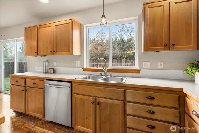 a kitchen with stainless steel appliances granite countertop white cabinets window and sink