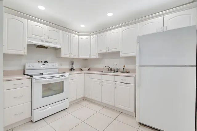 a kitchen with granite countertop white cabinets and white appliances