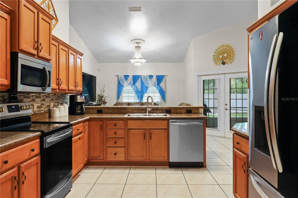 1 Elder Place Palm Coast, FL 32164 - Photo 9 of 34 a kitchen with stainless steel appliances granite countertop a stove top oven a sink a counter space and cabinets