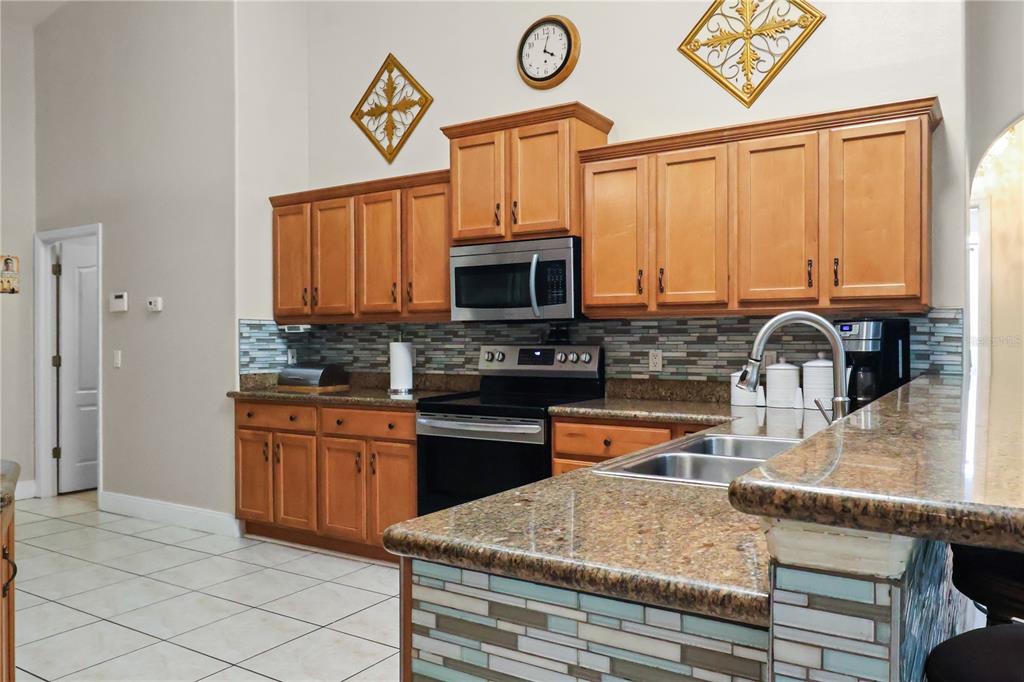1 Elder Place Palm Coast, FL 32164 - Photo 10 of 34 a kitchen with stainless steel appliances granite countertop a stove a sink and a microwave