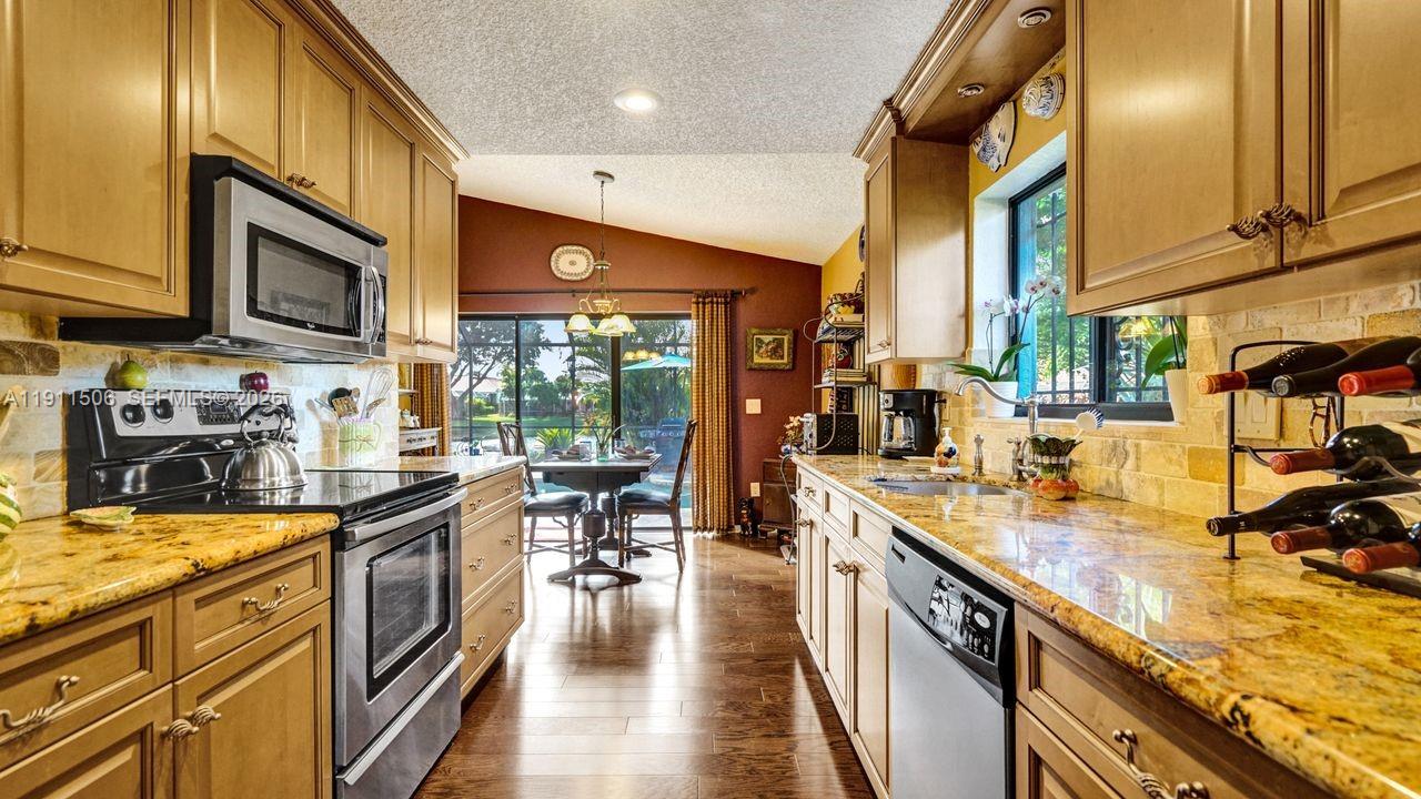 10858 White Aspen Lane Boca Raton, FL 33428 - Photo 11 of 72 a kitchen with stainless steel appliances granite countertop sink stove top oven and cabinets