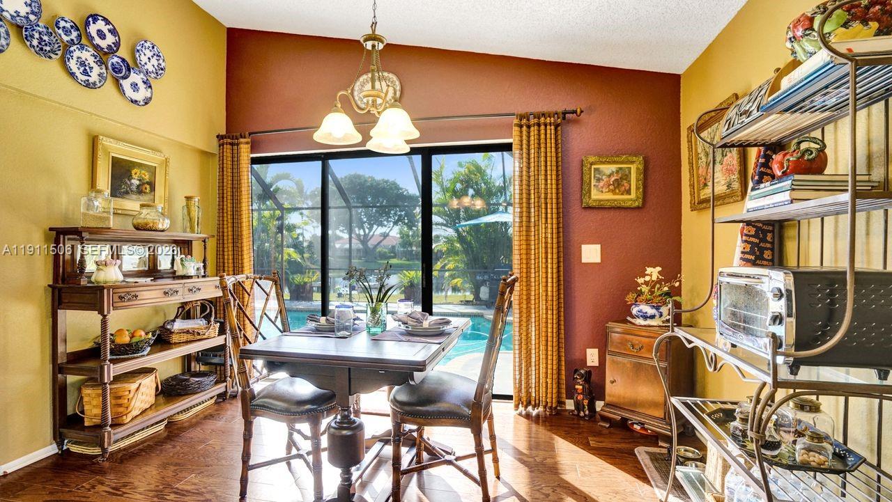 10858 White Aspen Lane Boca Raton, FL 33428 - Photo 15 of 72 a view of a dining room with furniture large window and wooden floor