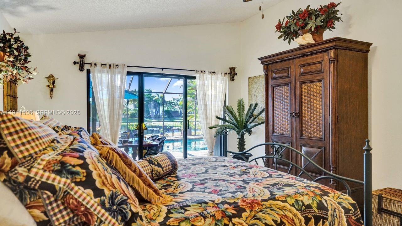 10858 White Aspen Lane Boca Raton, FL 33428 - Photo 26 of 72 a bedroom with a bed and large windows