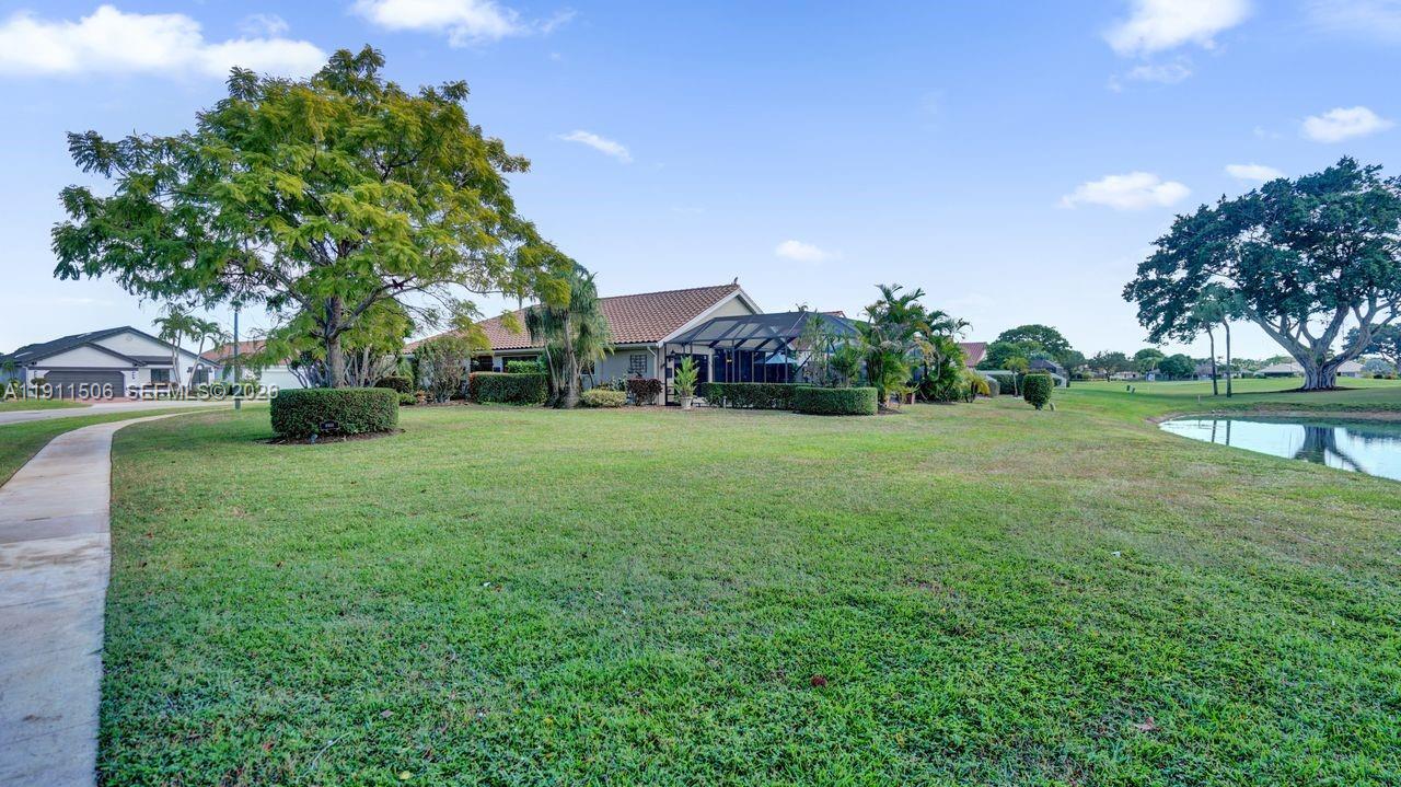 10858 White Aspen Lane Boca Raton, FL 33428 - Photo 46 of 72 a view of a park with large trees and a wooden fence