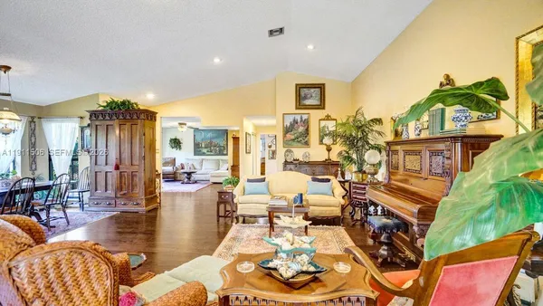 a kitchen with stainless steel appliances granite countertop a refrigerator a stove and a wooden floor