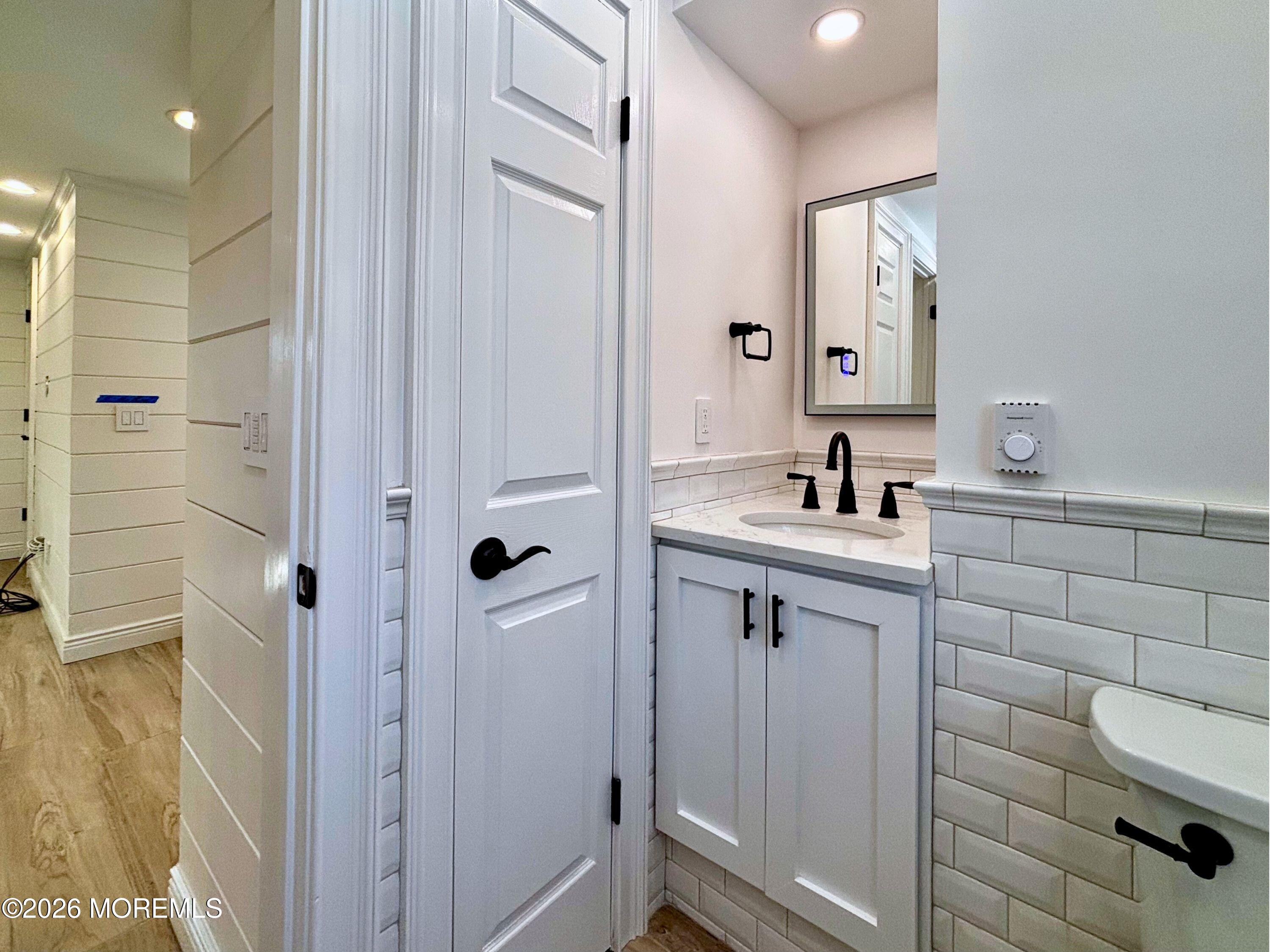 2364 Hurley Pond Road, Unit BACK TOP Wall, NJ 07719 - Photo 11 of 11 a bathroom with a shower sink and mirror