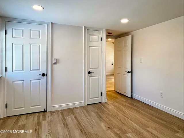 an empty room with wooden floor and closet area