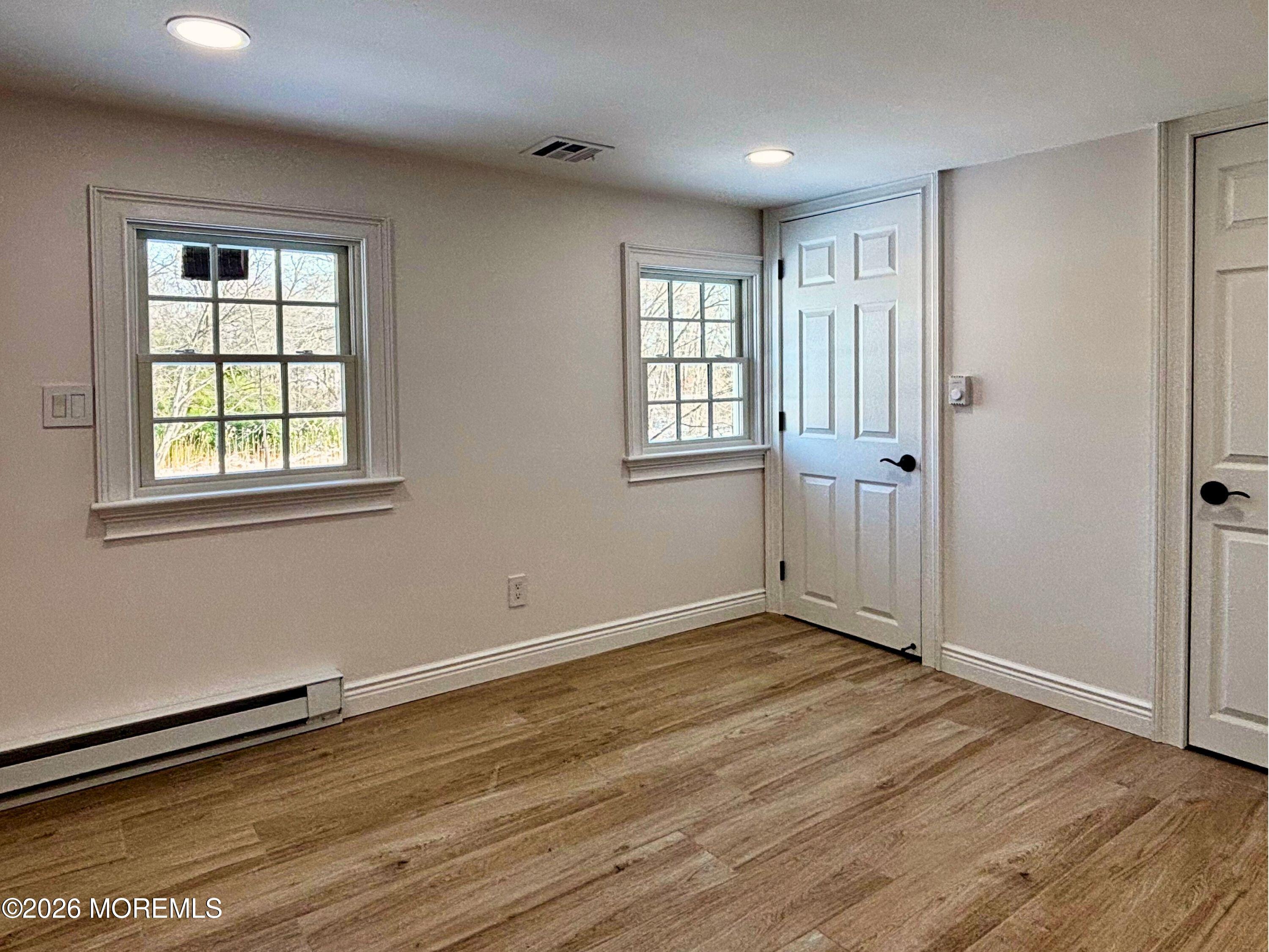 2364 Hurley Pond Road, Unit BACK TOP Wall, NJ 07719 - Photo 5 of 11 an empty room with wooden floor and windows