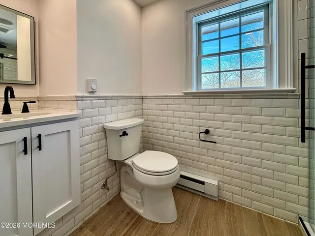 a bathroom with a toilet a sink and mirror