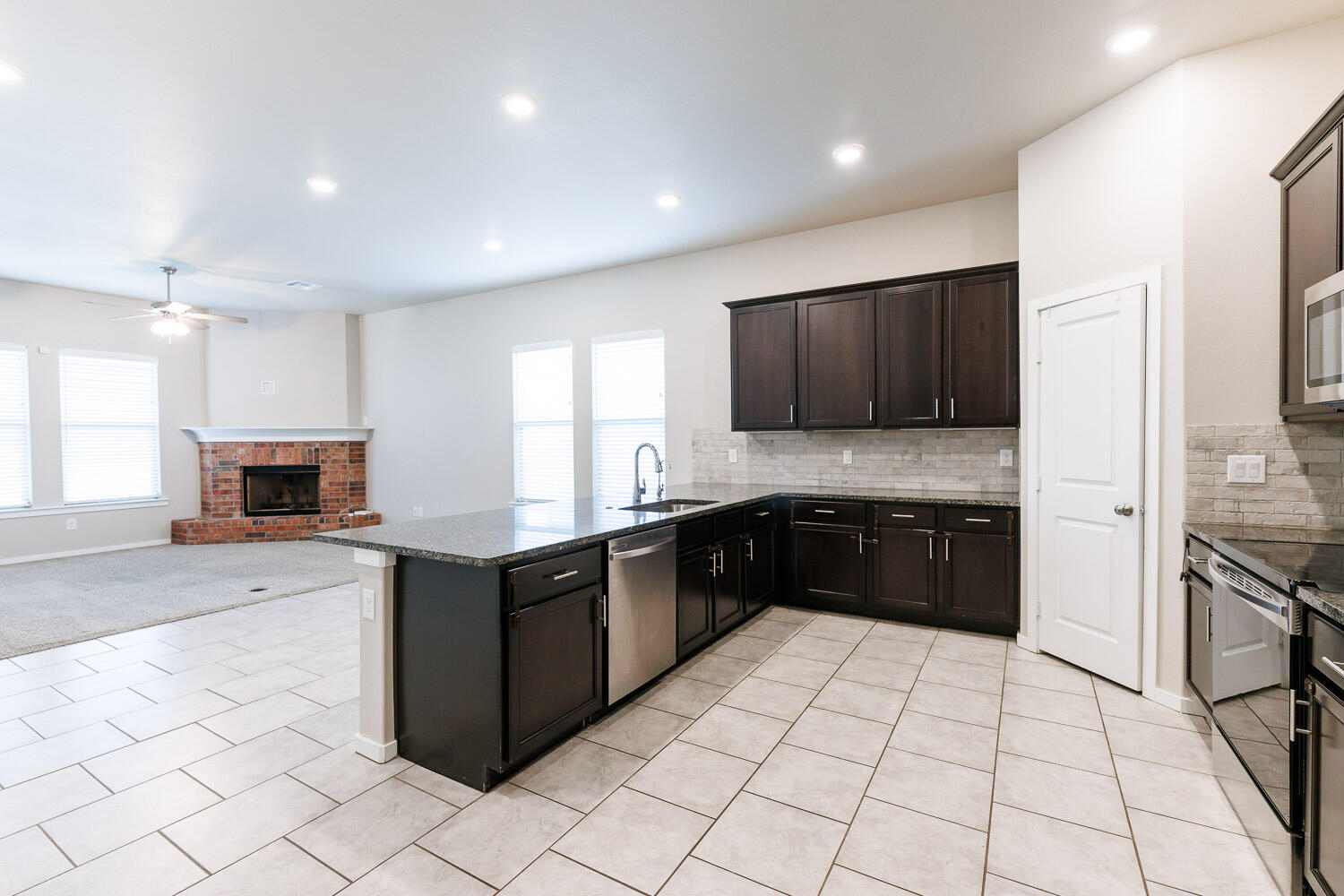 7509 26th Street Lubbock, TX 79407 - Photo 11 of 48 a large kitchen with a stove top oven a sink dishwasher and a refrigerator