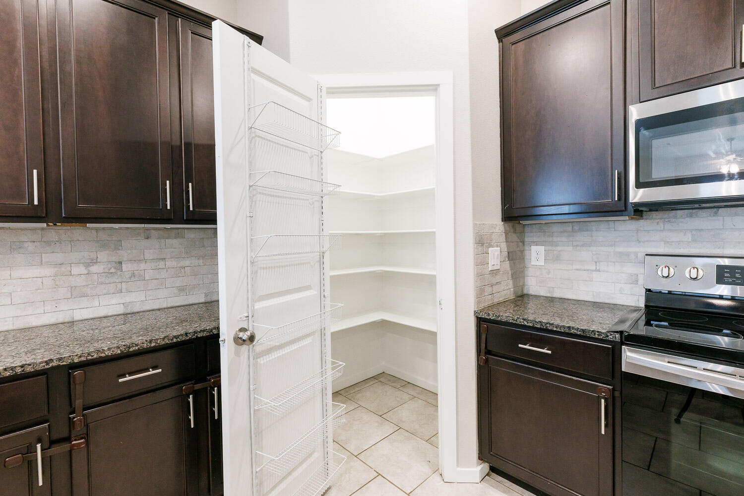 7509 26th Street Lubbock, TX 79407 - Photo 14 of 48 a kitchen with stainless steel appliances granite countertop a stove and a microwave