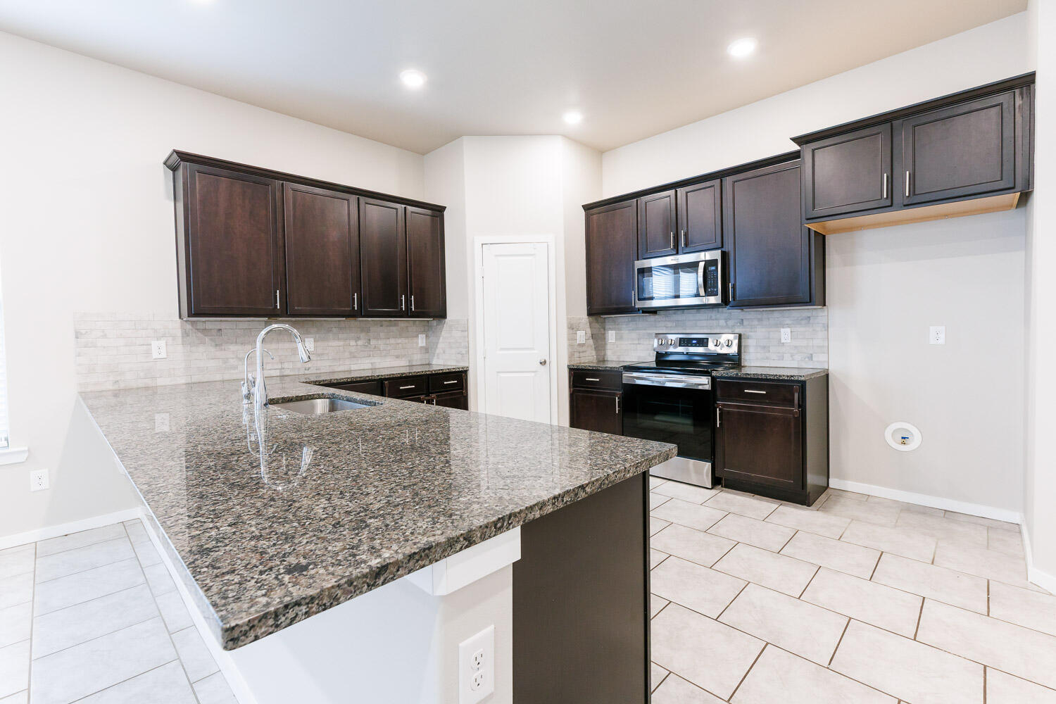 7509 26th Street Lubbock, TX 79407 - Photo 18 of 48 a kitchen with stainless steel appliances granite countertop a sink stove and refrigerator