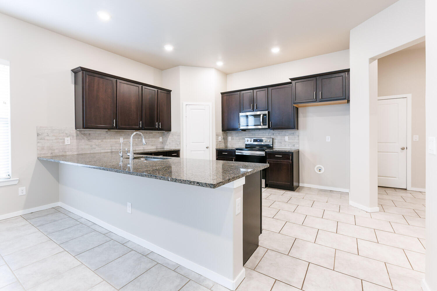 7509 26th Street Lubbock, TX 79407 - Photo 19 of 48 a kitchen with stainless steel appliances a refrigerator sink and microwave