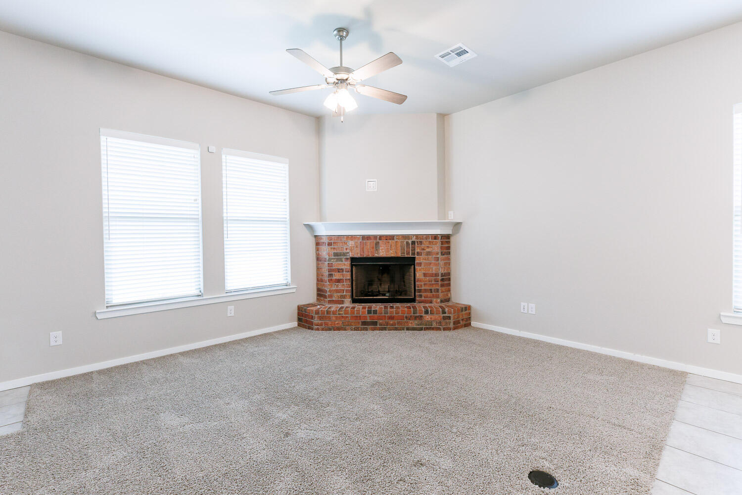 7509 26th Street Lubbock, TX 79407 - Photo 4 of 48 an empty room with windows and fireplace