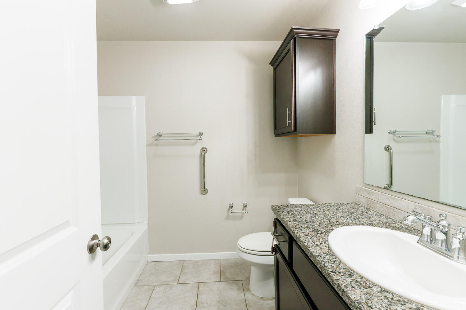 7509 26th Street Lubbock, TX 79407 - Photo 42 of 48 a bathroom with a granite countertop sink a toilet and shower