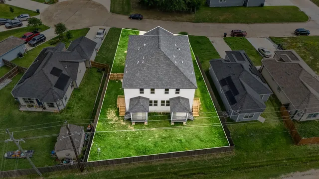 an aerial view of a house with a yard