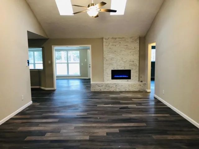 a view of empty room with wooden floor and fireplace
