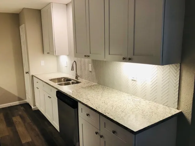 a kitchen with granite countertop cabinets and white appliances
